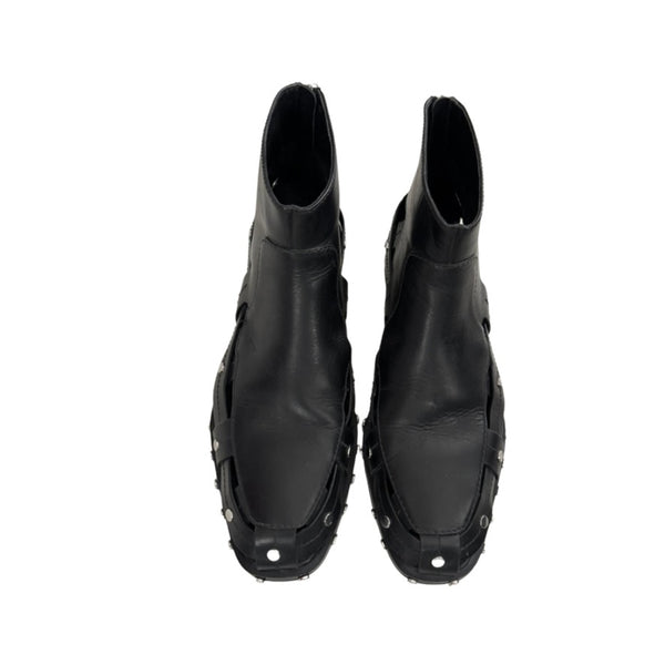 Pair of black leather boots with unique design on a white background