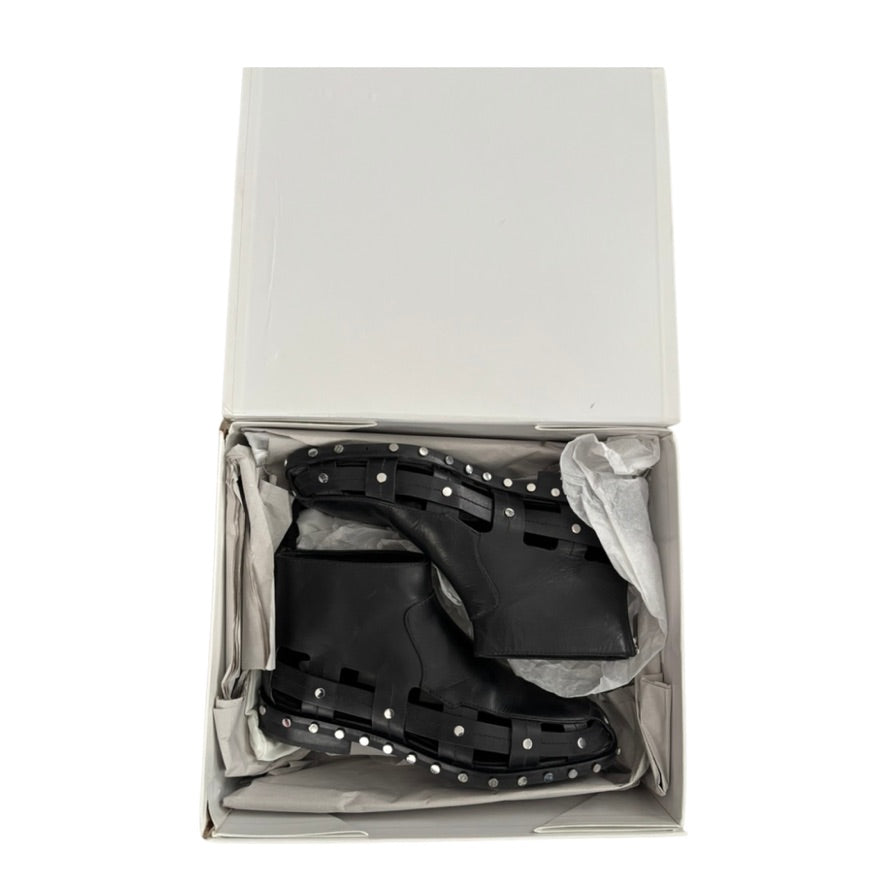 Black studded boots in a white box on a white background