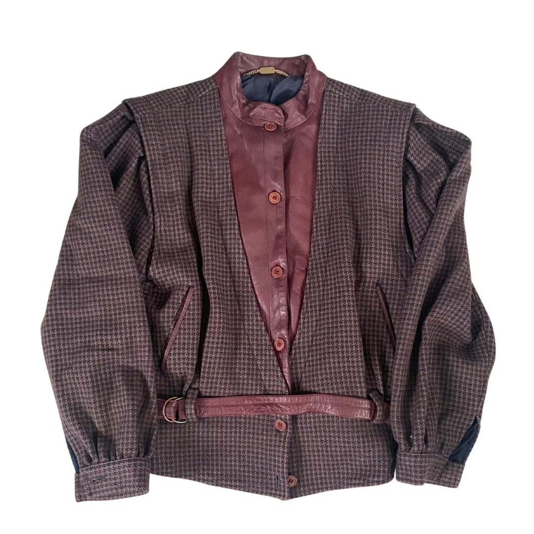 A vintage 80s checkered jacket with contrasting leather bib and belt, navy blue sleeves, and a high collar.