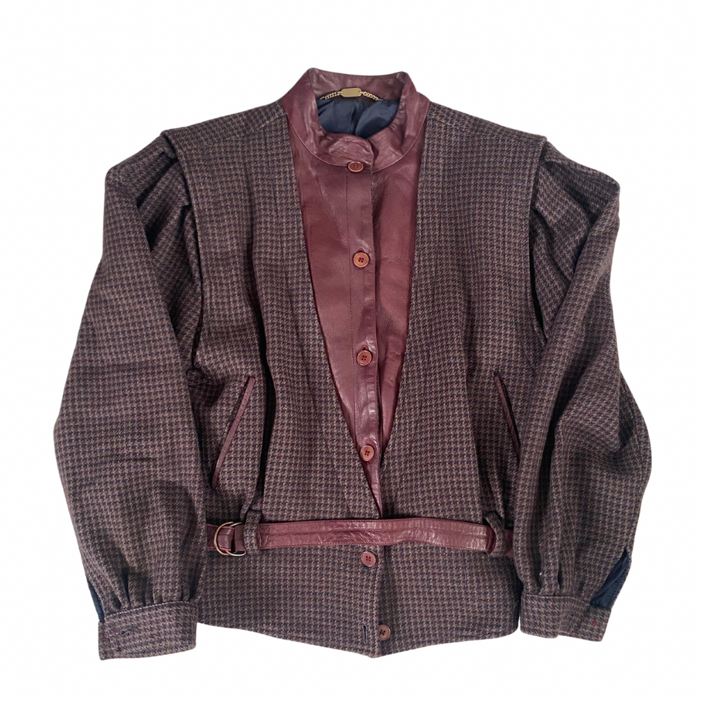 A vintage 80s checkered jacket with contrasting leather bib and belt, navy blue sleeves, and a high collar.