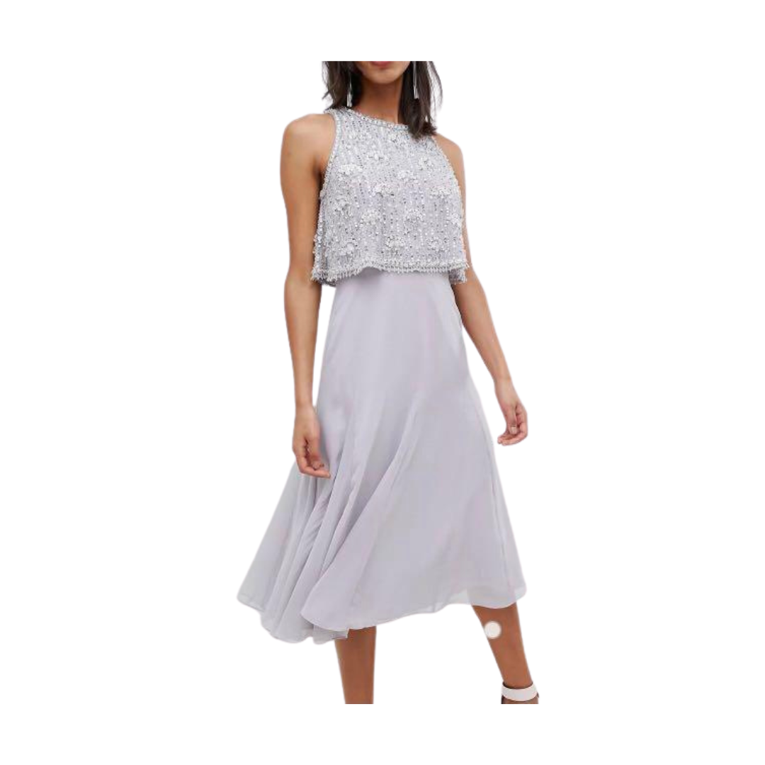 Woman wearing a light gray dress with a sequined top on a white background