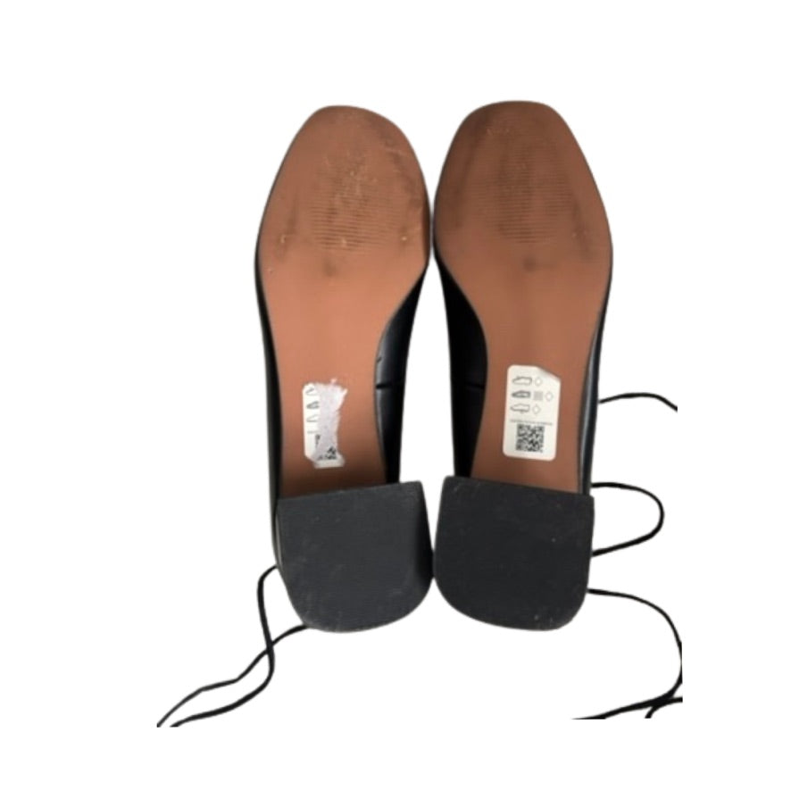 Black shoes with brown soles on a white background