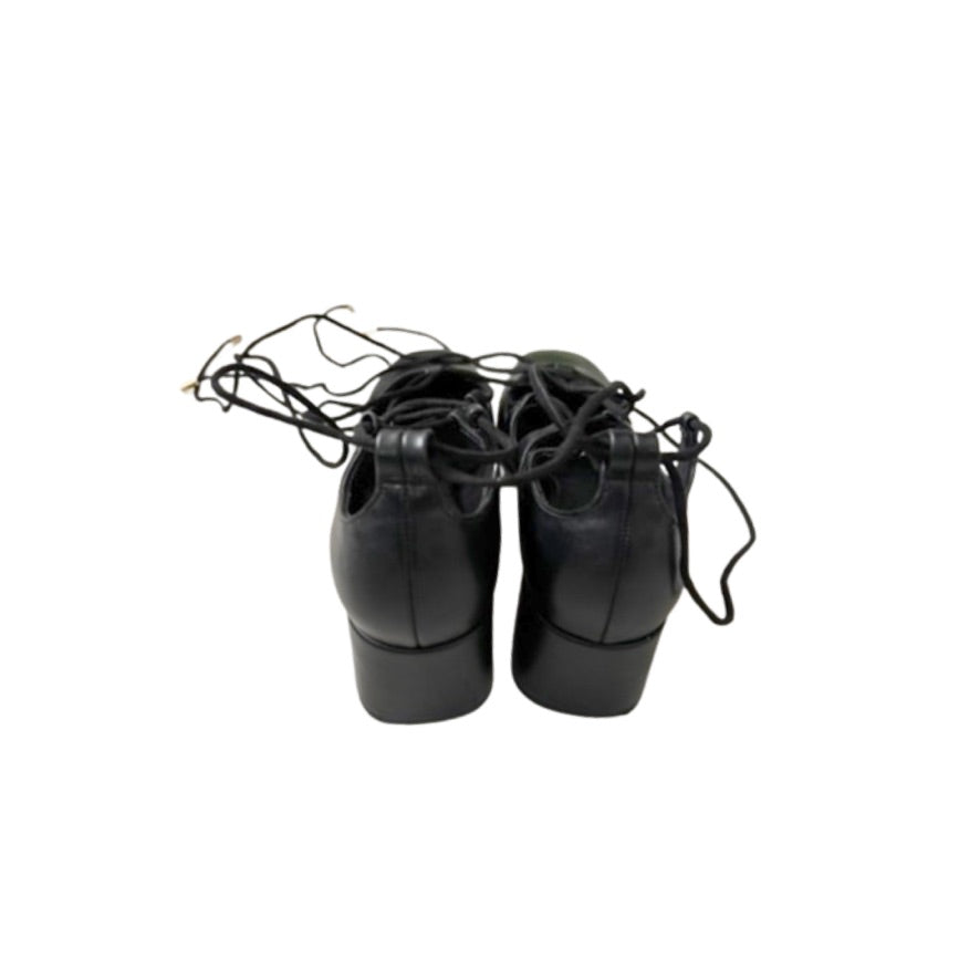Pair of black dance shoes with laces on a white background