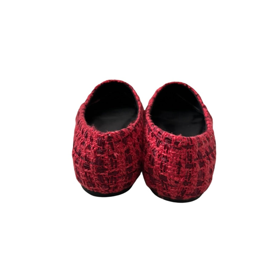 Pair of red flat shoes with a pattern on a white background