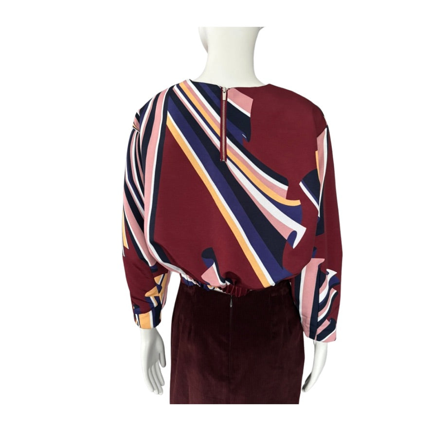 Colorful patterned dress on a mannequin against a white background