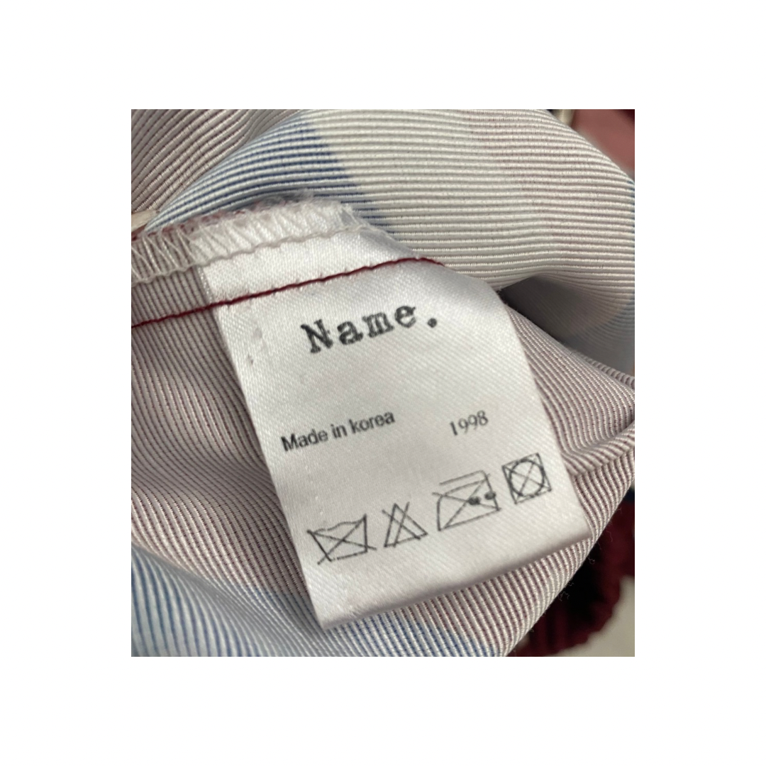 Clothing label with text and symbols on a striped fabric background