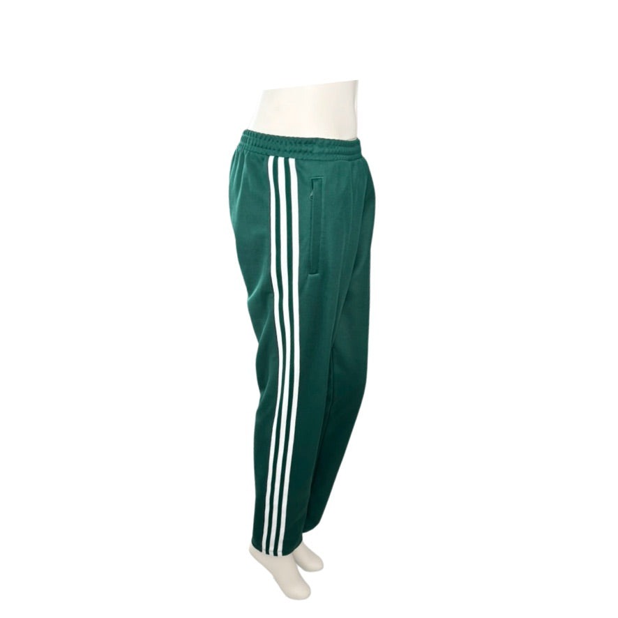 Green track pants with white stripes on a mannequin against a white background
