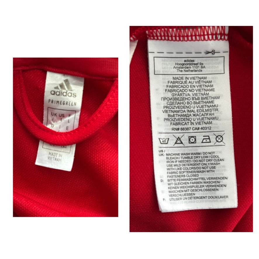 Close-up of an Adidas label on a red garment with text details.
