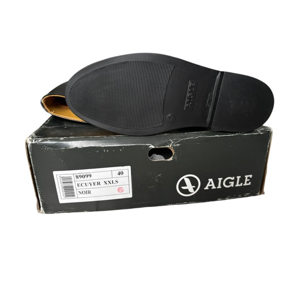 Black shoe sole on a black Aigle shoe box with white text