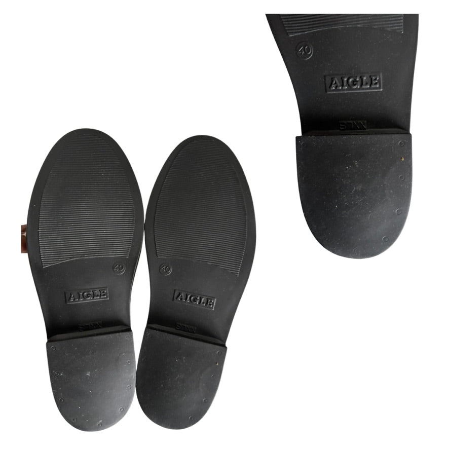 Black rubber sole of a boot with 'Aigle' branding on a white background