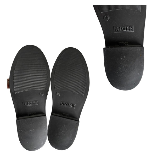 Black rubber sole of a boot with 'Aigle' branding on a white background