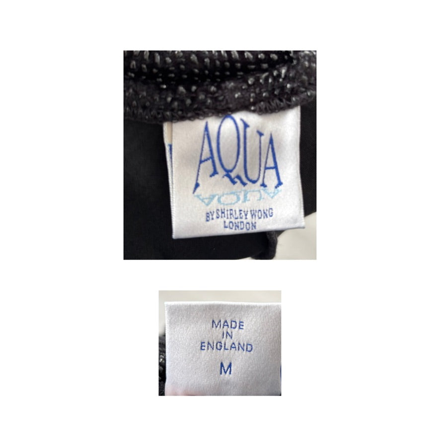 Close-up of a clothing label with 'Aqua' branding and 'Made in England' text.