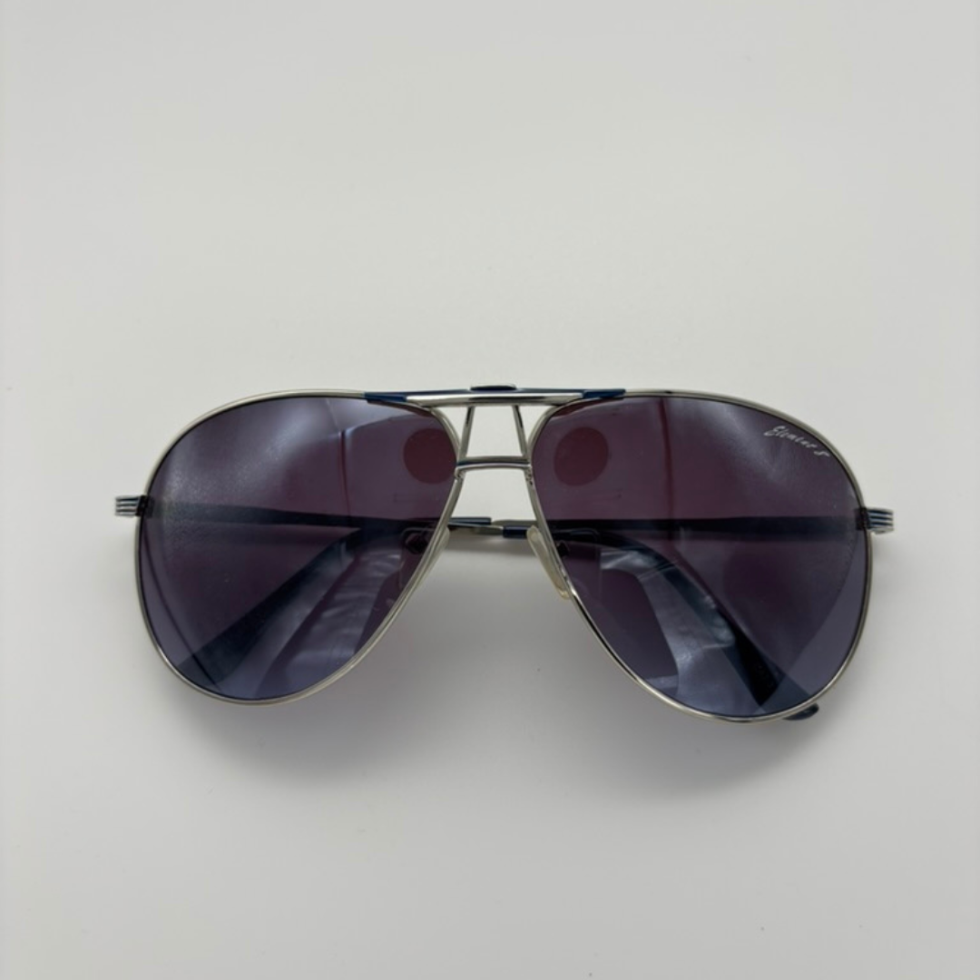 Aviator sunglasses with dark lenses on a light gray background