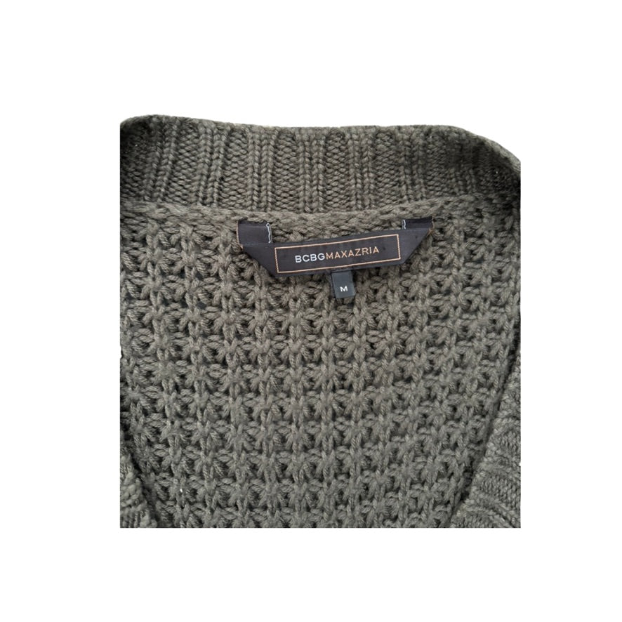 Close-up of a textured sweater with a brand label on a white background