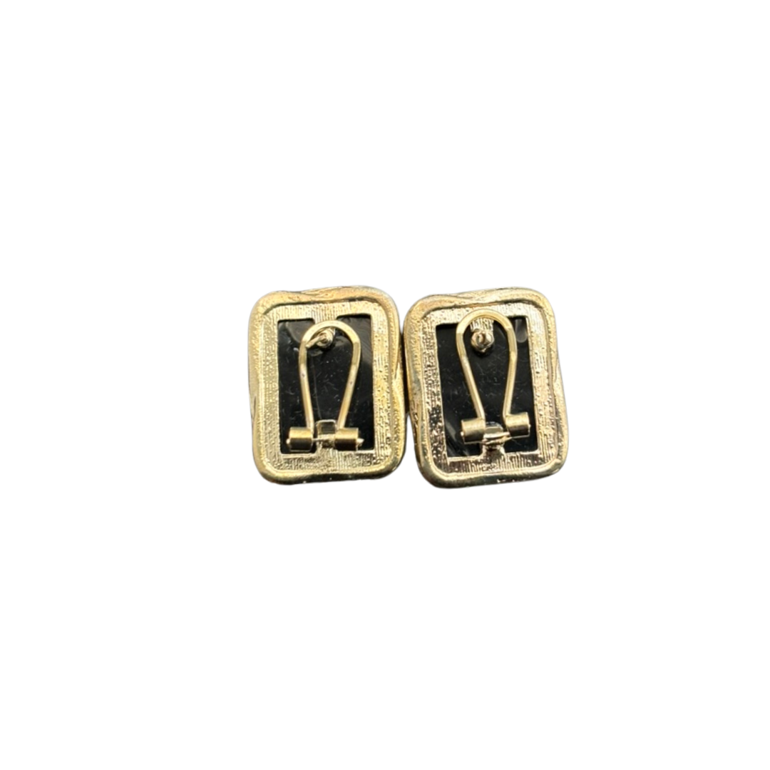 Pair of gold and black earrings on a white background