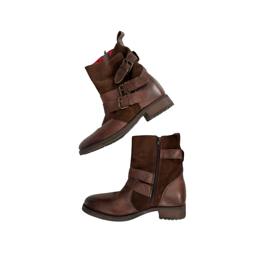 Pair of brown leather boots with buckles on a white background