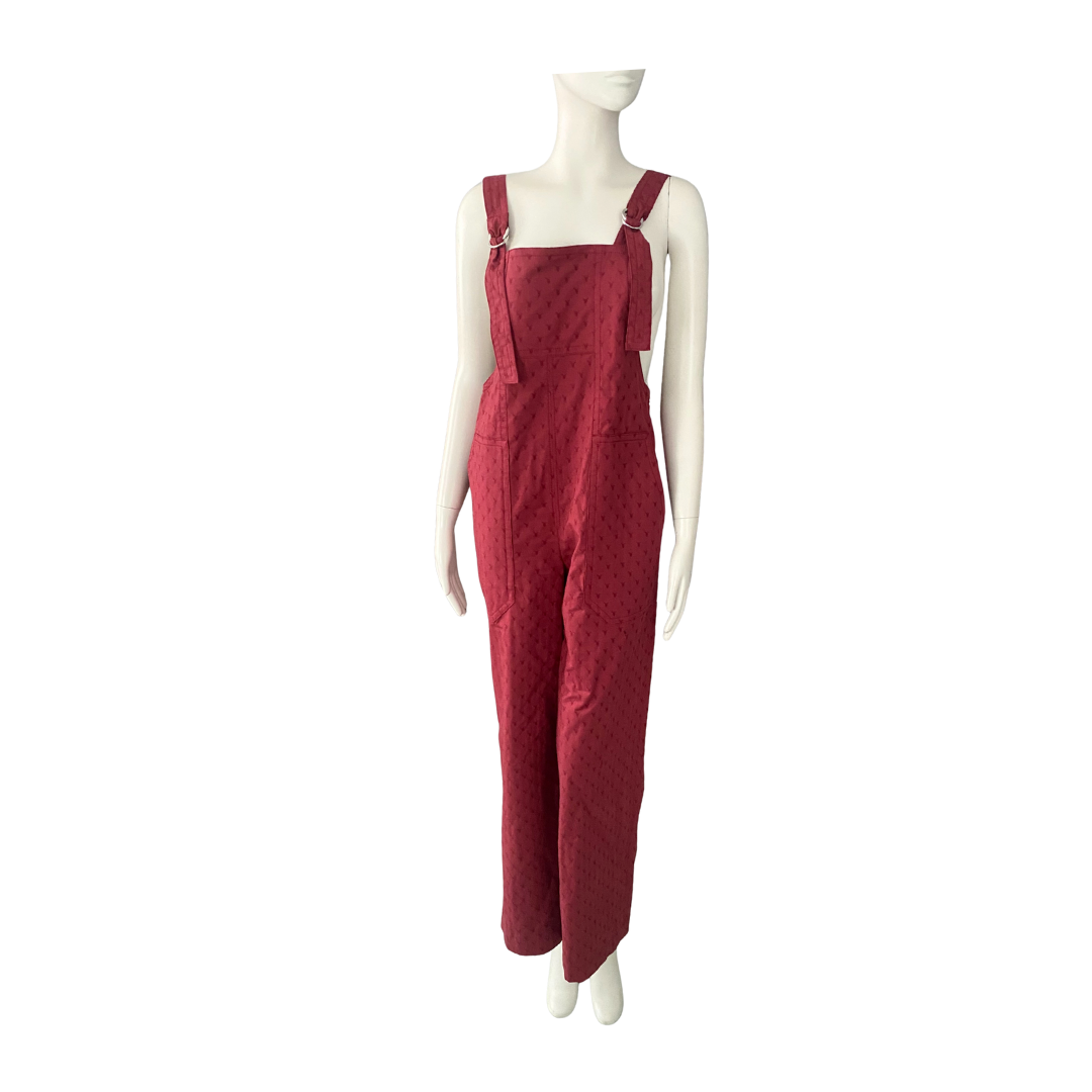Red jumpsuit on a mannequin against a white background
