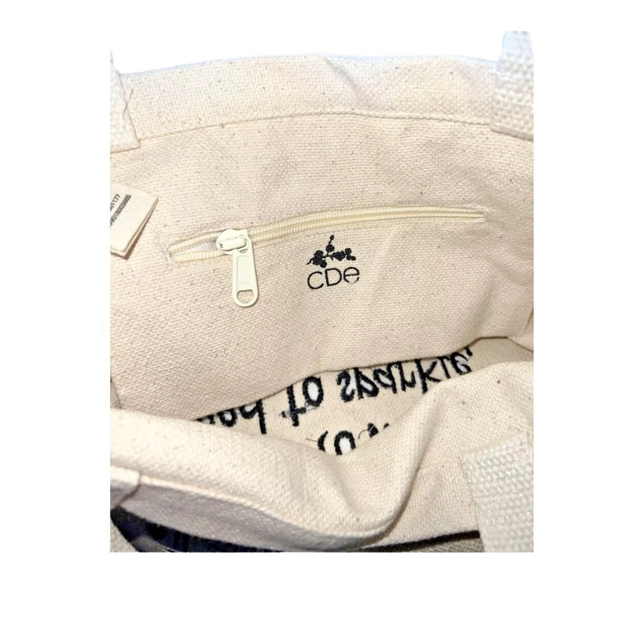 Close-up of a beige bag with a zipper and 'CDe' branding.