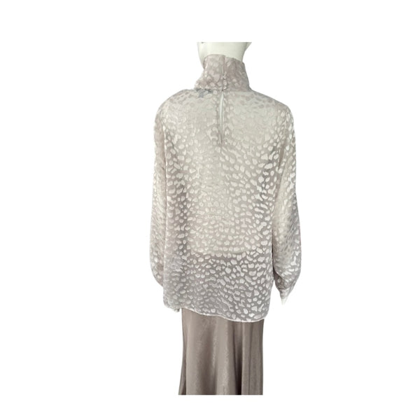 Sheer blouse with a pattern on a mannequin against a white background