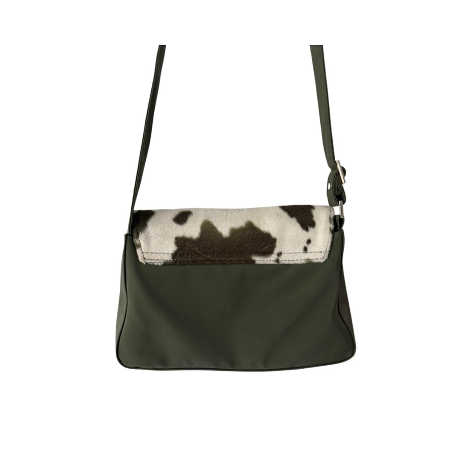 Green handbag with a cow print flap on a white background