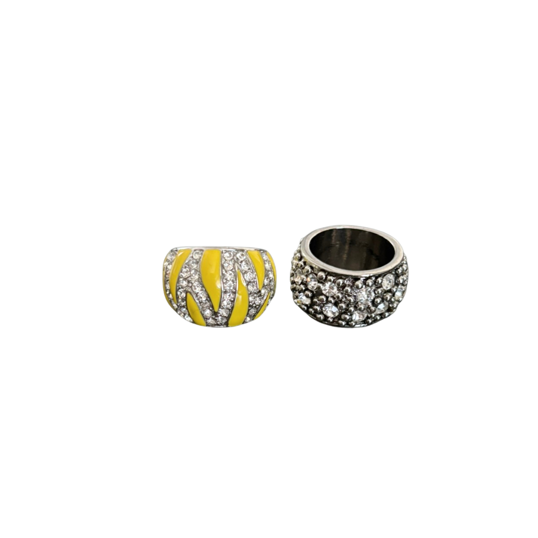 Two decorative beads, one with yellow and black pattern and the other with clear stones, on a white background.