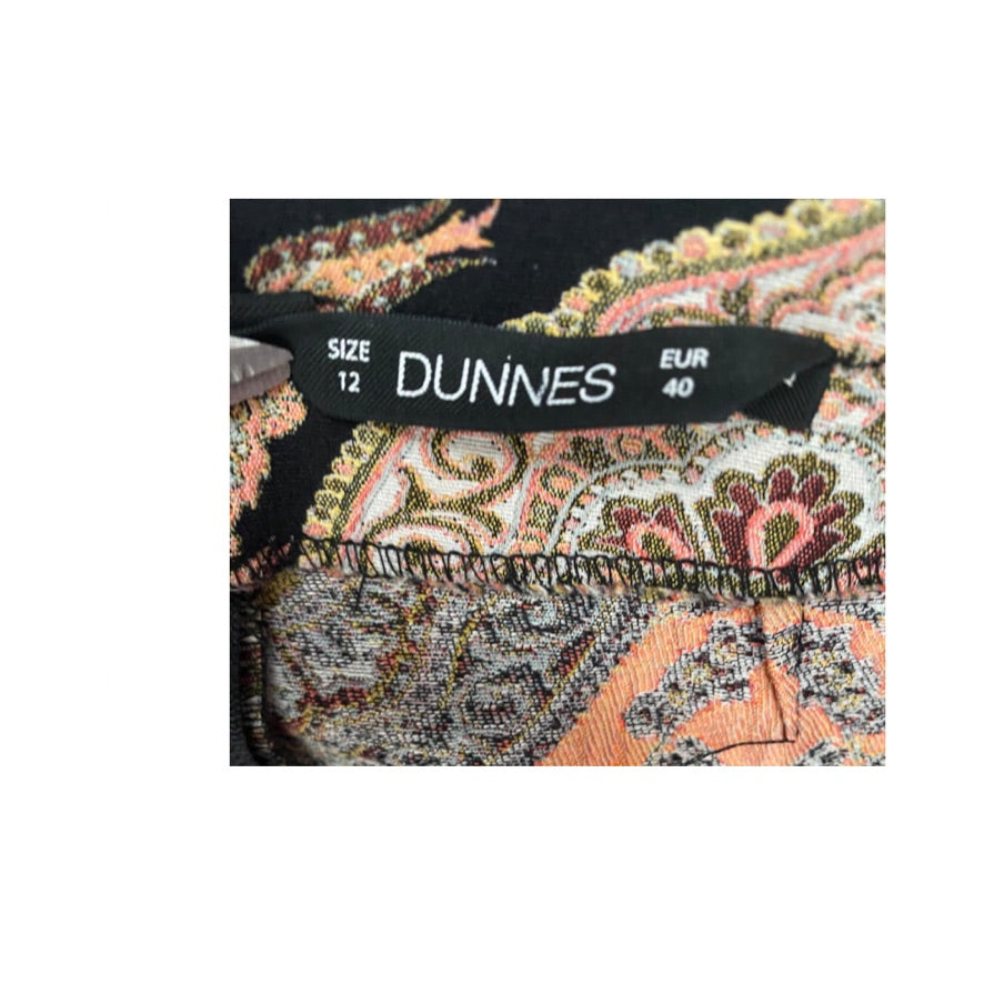 Close-up of a patterned fabric with a Dunnes branded size label.