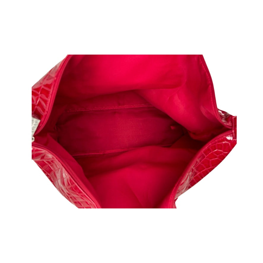 Close-up of a red handbag with a textured surface on a white background