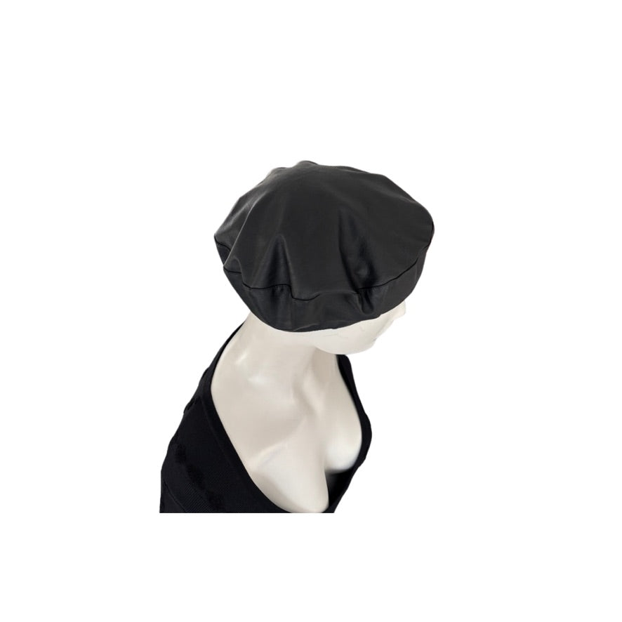 Black beret on a mannequin head against a white background