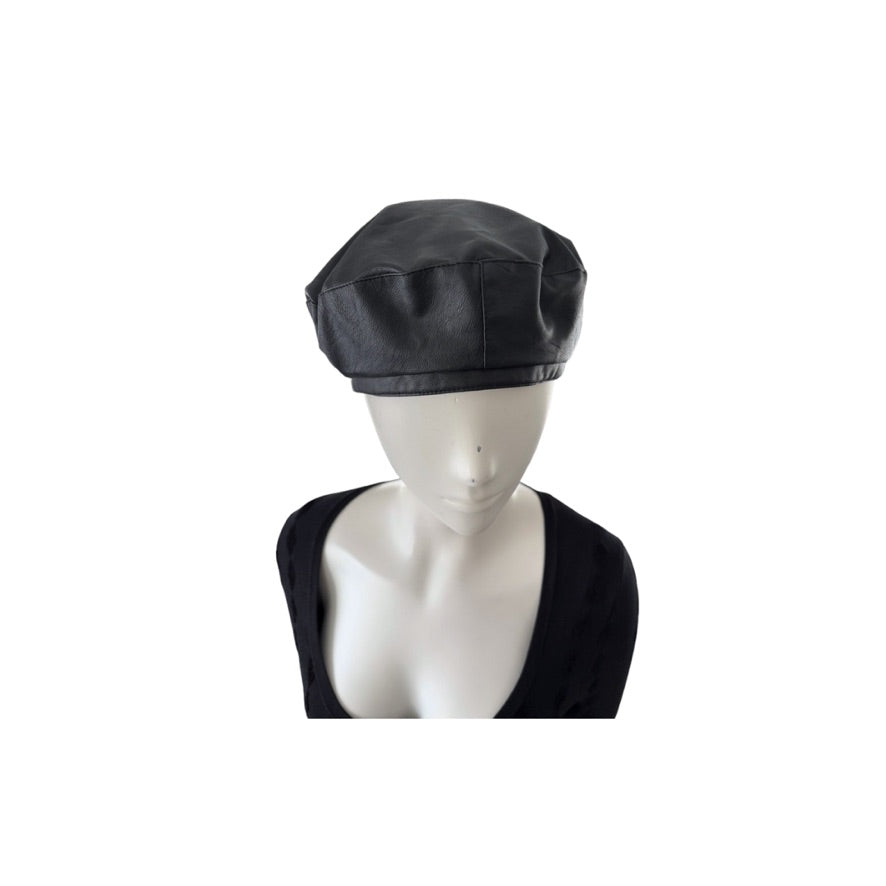 Black leather beret on a mannequin head against a white background