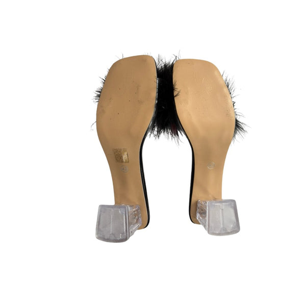 Pair of beige shoe soles with black fur on a white background