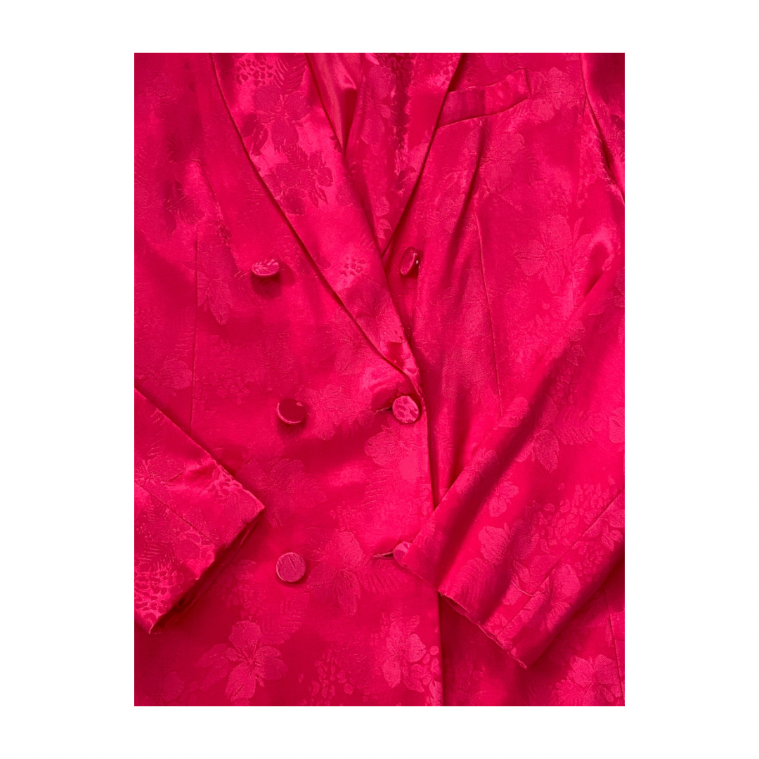 Close-up of a bright pink textured fabric with buttons on a white background