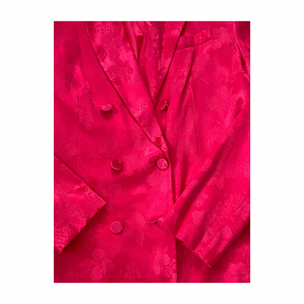Close-up of a bright pink textured fabric with buttons on a white background