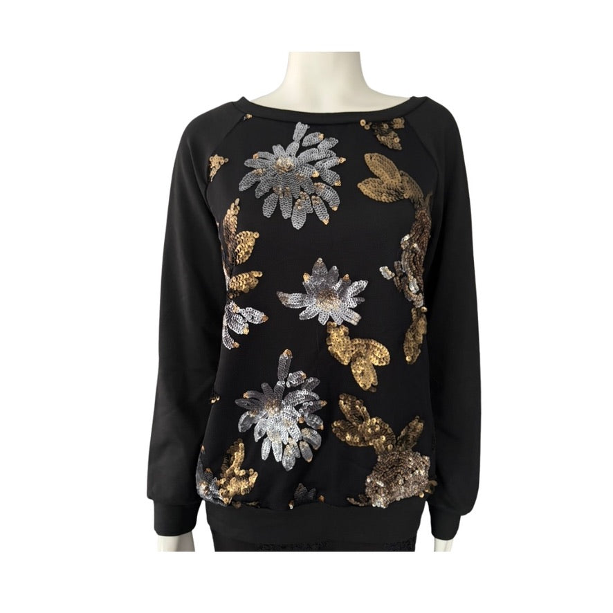 Black sweater with gold and silver floral patterns on a mannequin against a white background