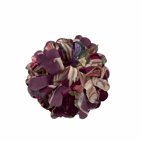 Multicolored fabric brooch on a white background