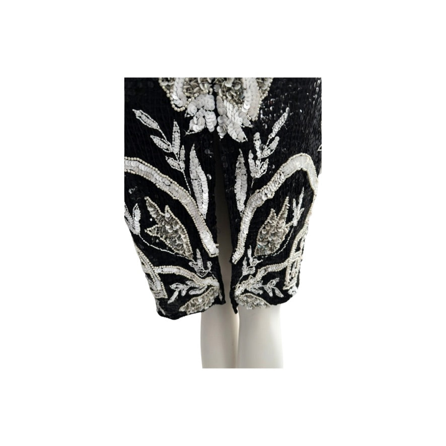 Black pants with silver floral sequin embellishments on a white background