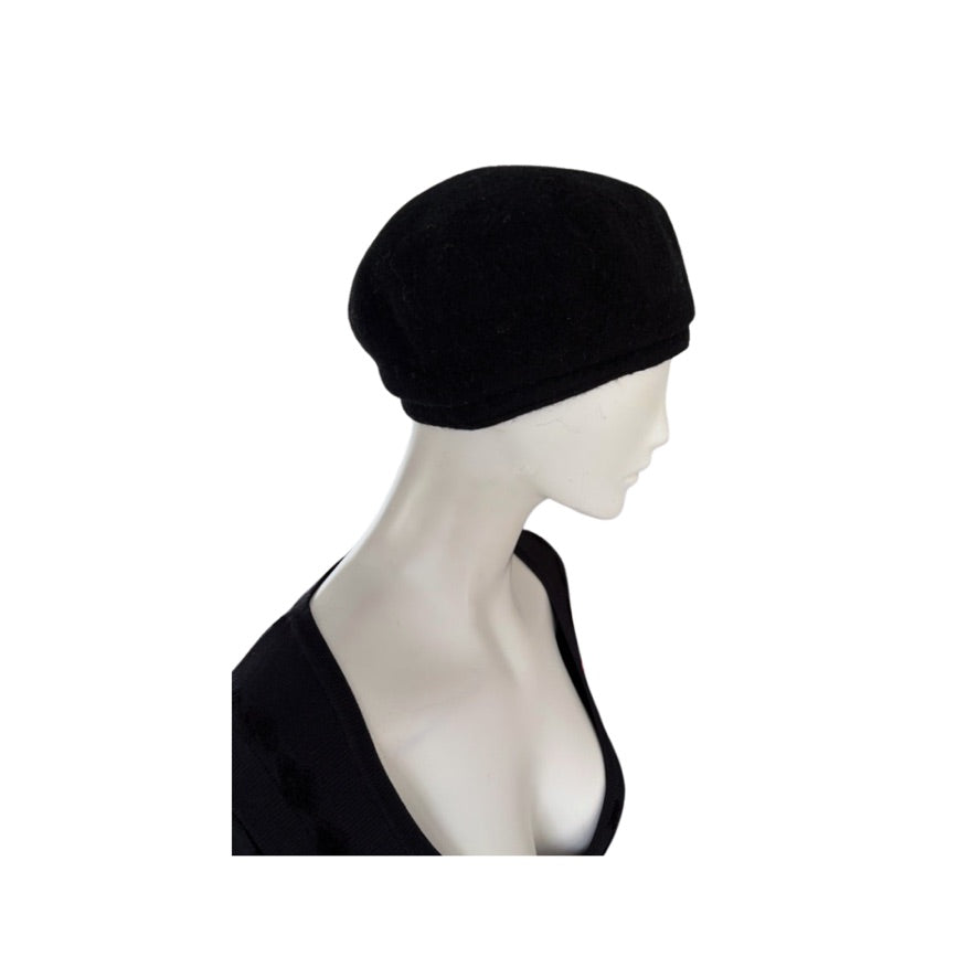 Black beret on a mannequin head against a white background