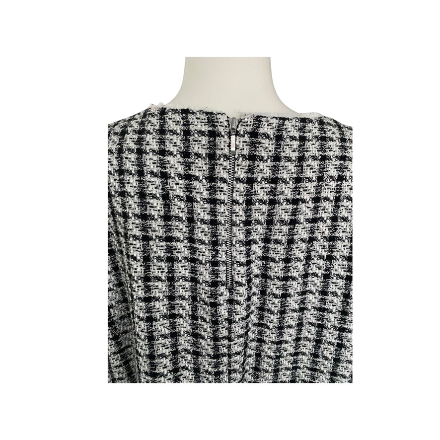 Black and white checkered dress on a mannequin against a white background