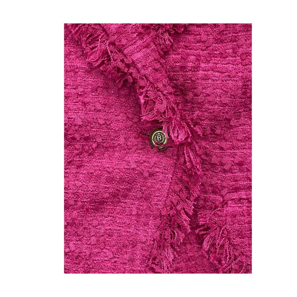 Close-up of a pink textured fabric with ruffled edge and a button on a white background