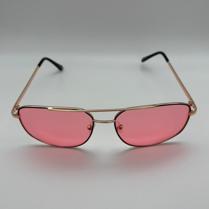 Sunglasses with pink lenses and gold frames on a gray background