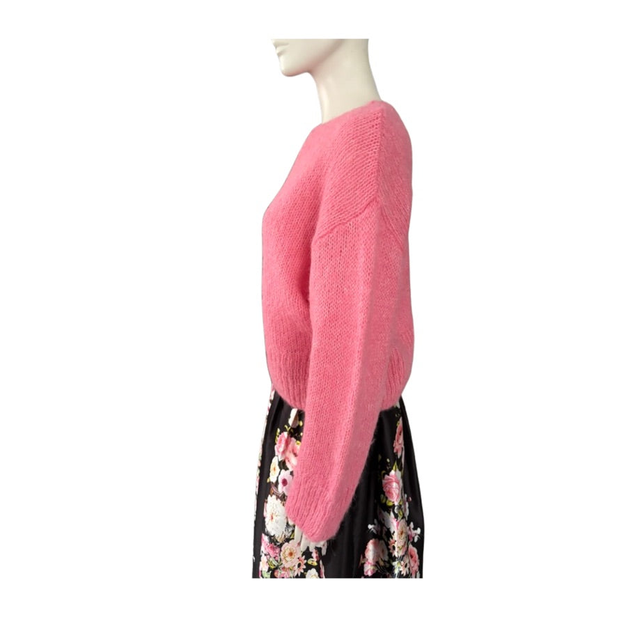 Mannequin wearing a pink sweater with a white background