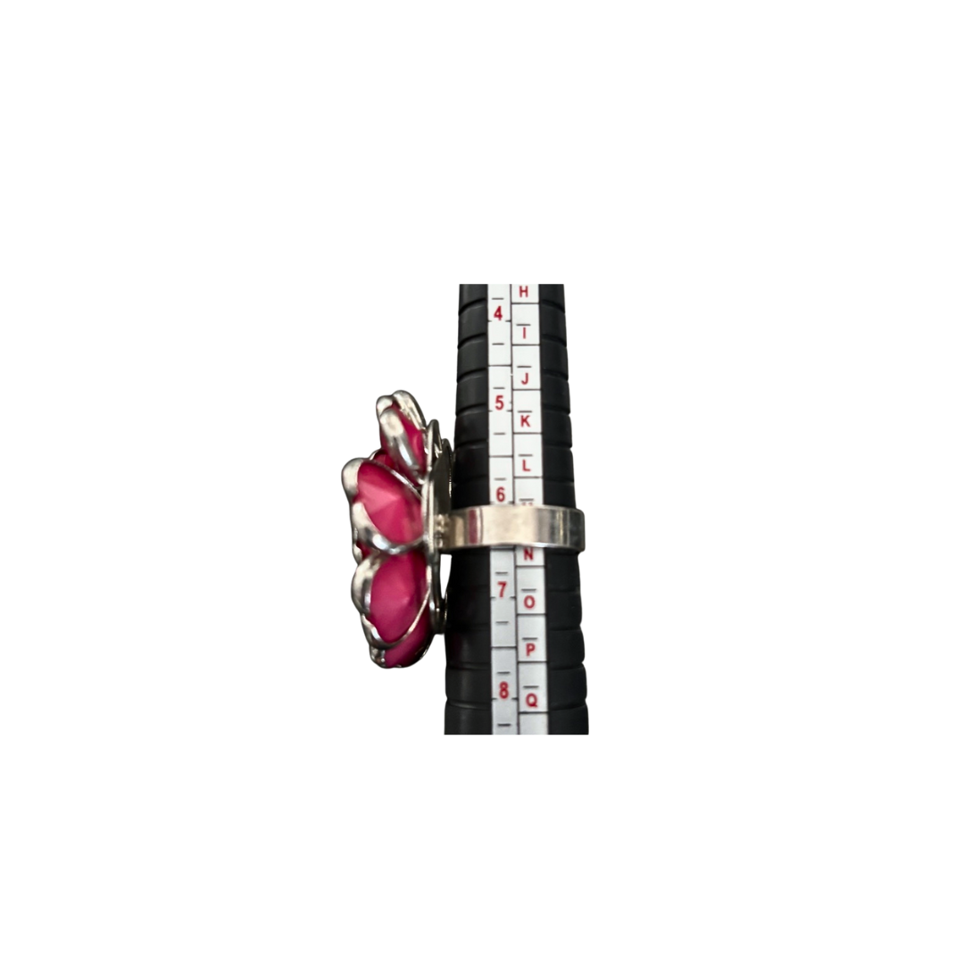 Ring with pink gemstones and silver band on a white background