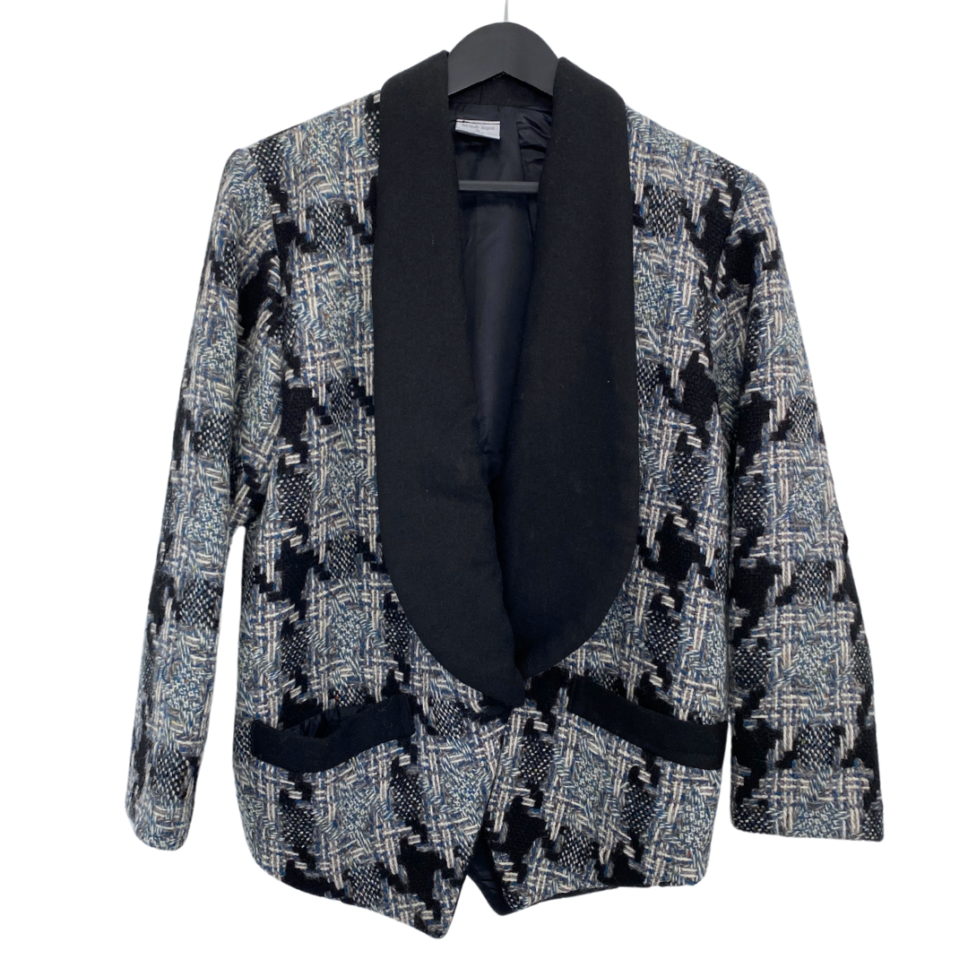 Vintage tweed tuxedo jacket in gray, blue, and black with a shawl collar and long sleeves, displayed on a hanger.