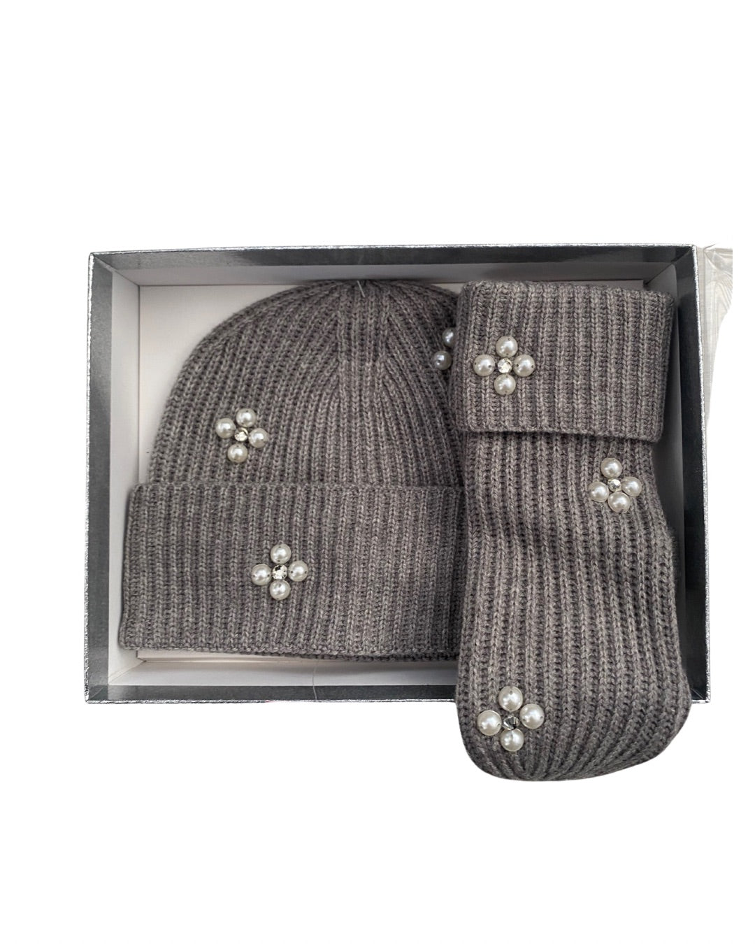 Grey knit hat and mittens set with decorative elements in a box on a white background