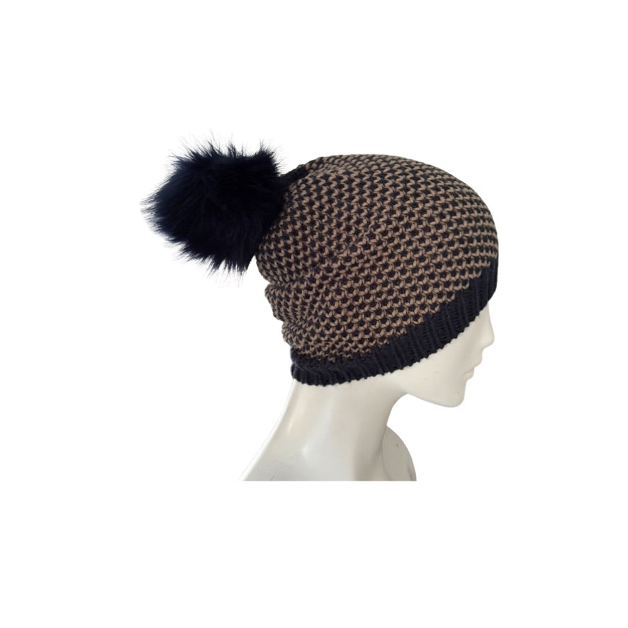 Knitted beanie with a pom-pom on a mannequin head against a white background