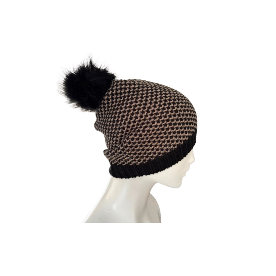 Knitted beanie with a black pom-pom on a mannequin head against a white background