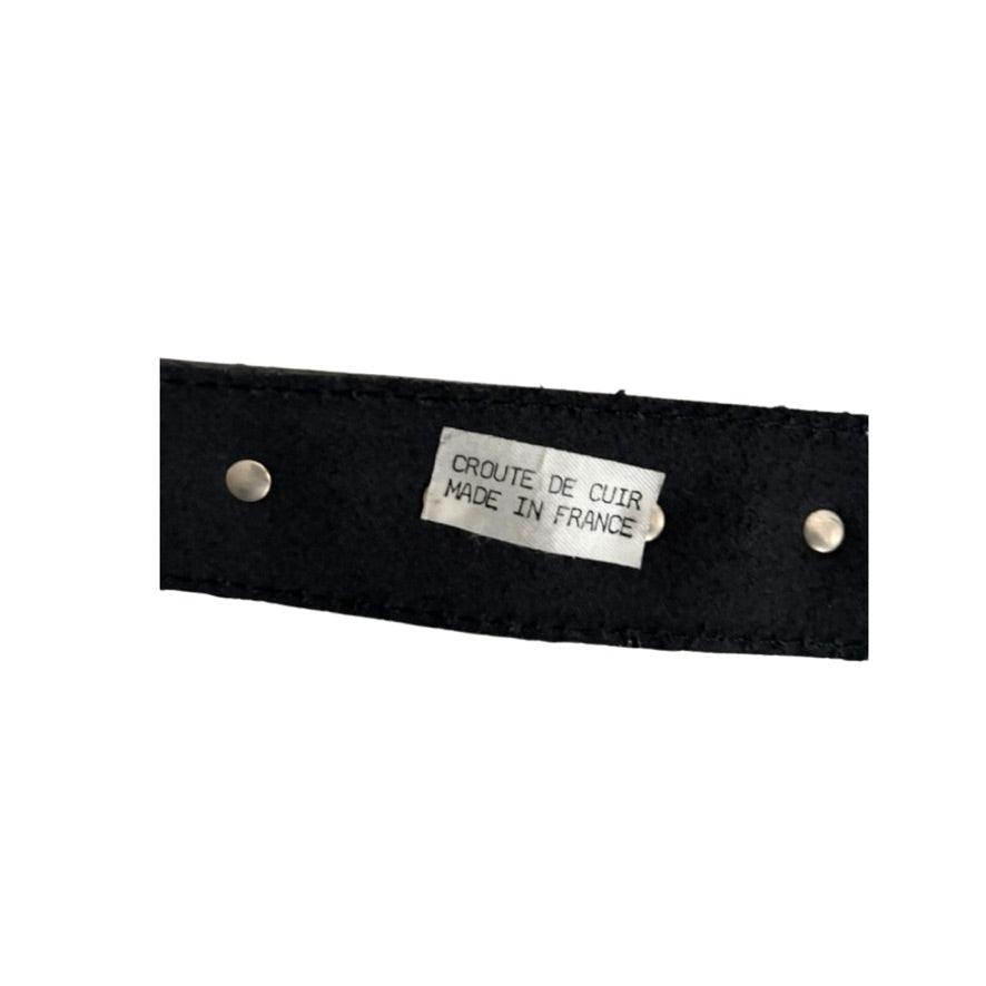 Black leather strap with a silver tag labeled 'Crète de Cuir Made in France' on a white background