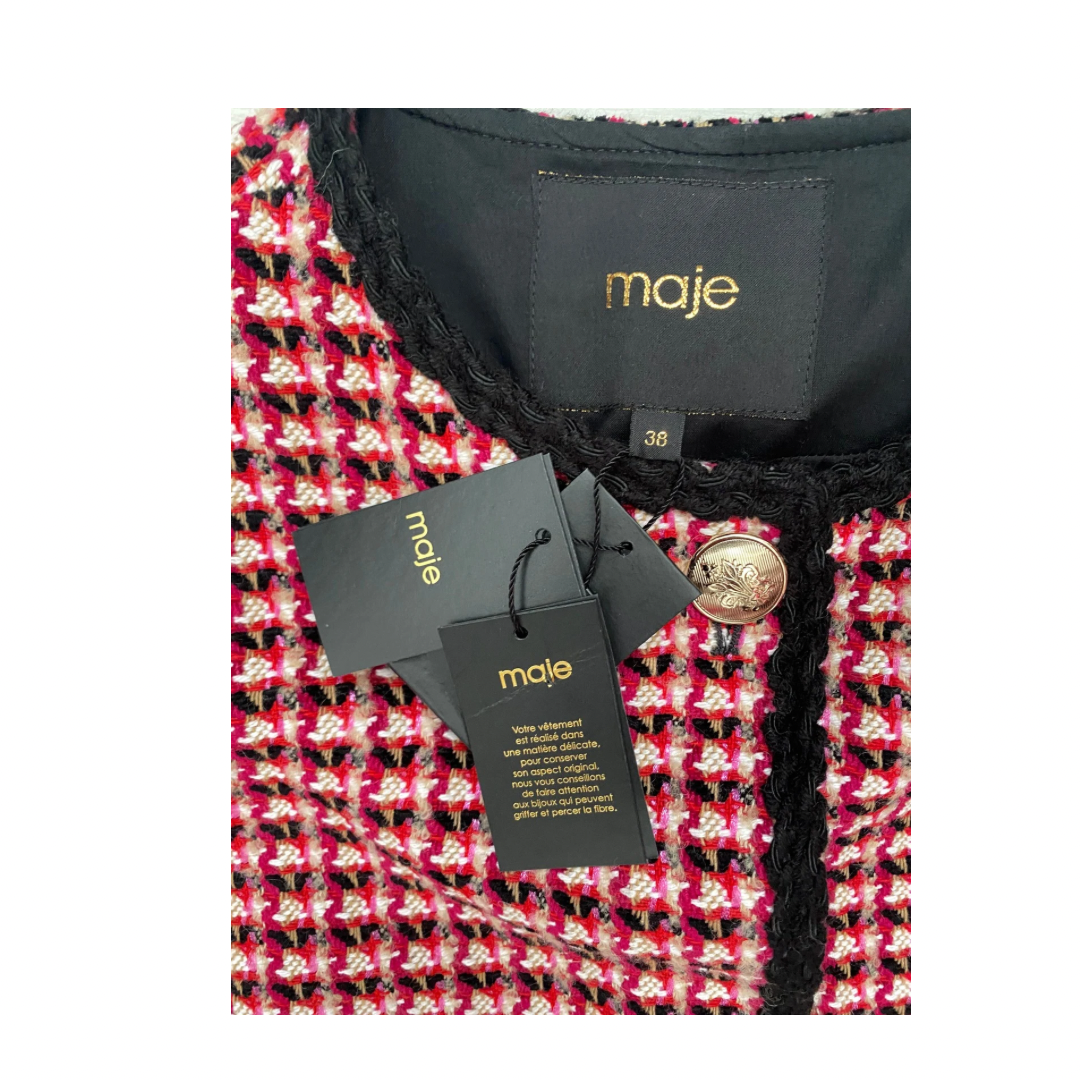 Close-up of a red and black patterned garment with 'maje' branding on a white background.