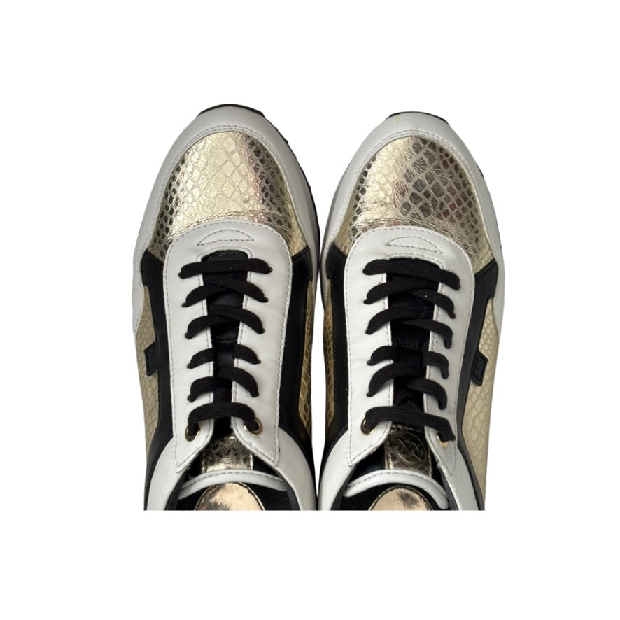 Pair of snakeskin-patterned sneakers with black laces on a white background