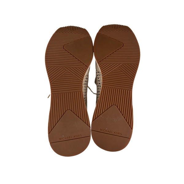 Brown sole of a shoe with 'Michael Kors' branding on a white background