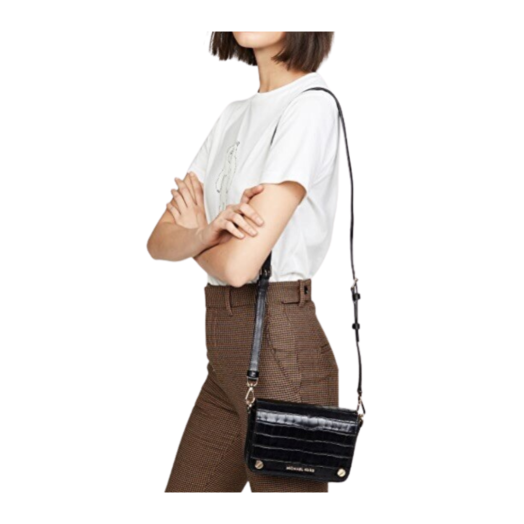 Person wearing a white shirt and brown pants with a black handbag on a white background